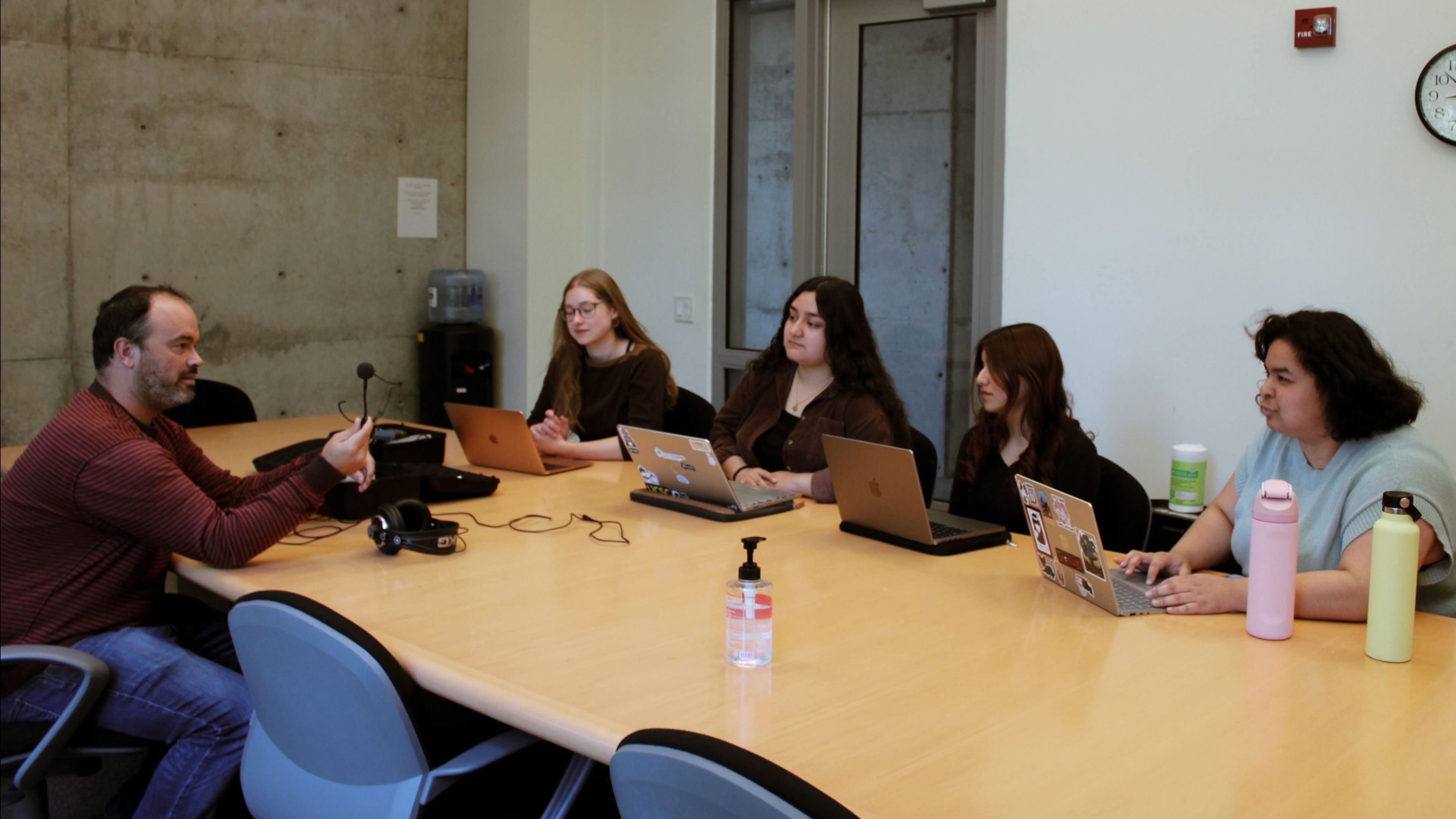 A group of researchers at a table receiving training from a professor